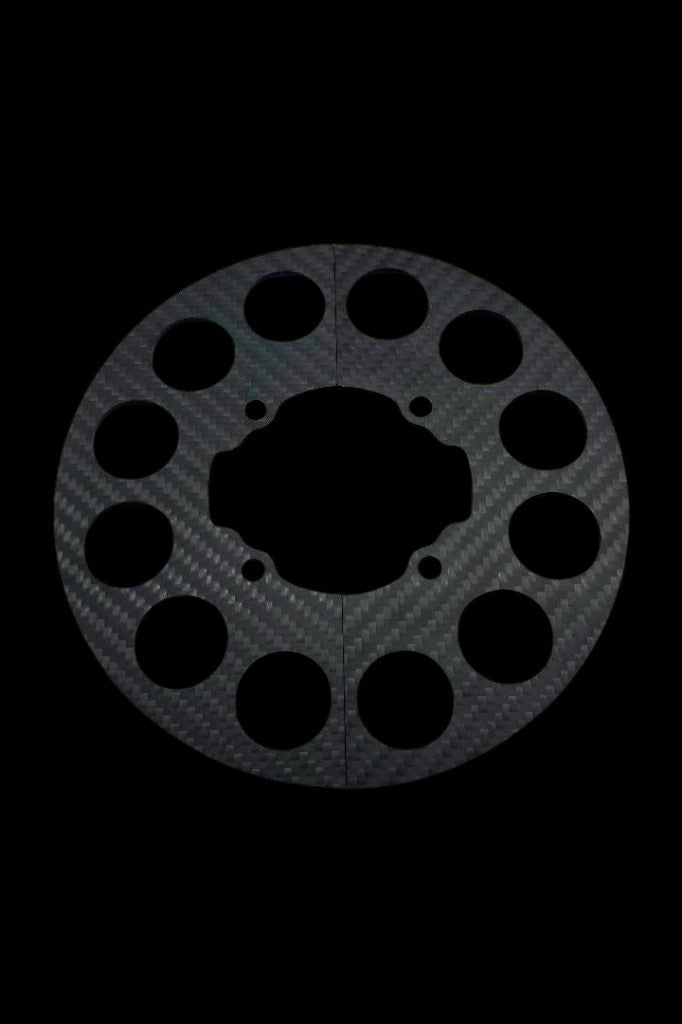 Woven carbon fiber split sprocket guard shown against black background, circular disc with precision lightening holes and central cutout for the mini hub.