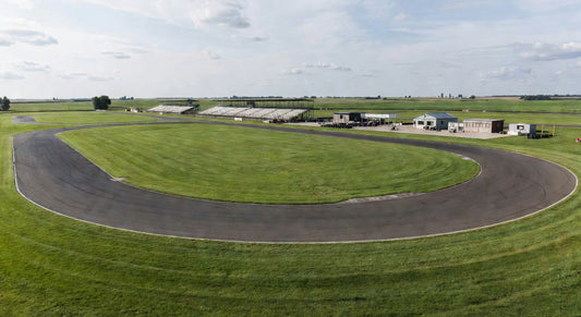 Midwest kart track landscape with open pits under cloudy skies.