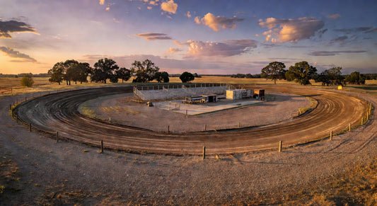 Sweeping landscape of a Midwest dirt kart track at dusk with open pits.