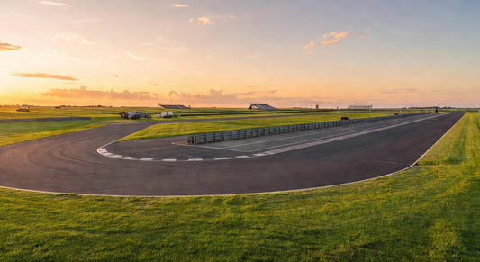 Sunset landscape of a sprint kart track with empty pits and grandstands.