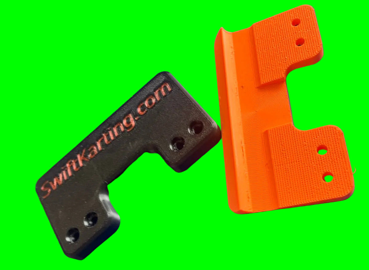 Black and orange plastic frame savers on a green background.  One is showing the backside showing the swiftKarting.com branding, the other is showing the top side.