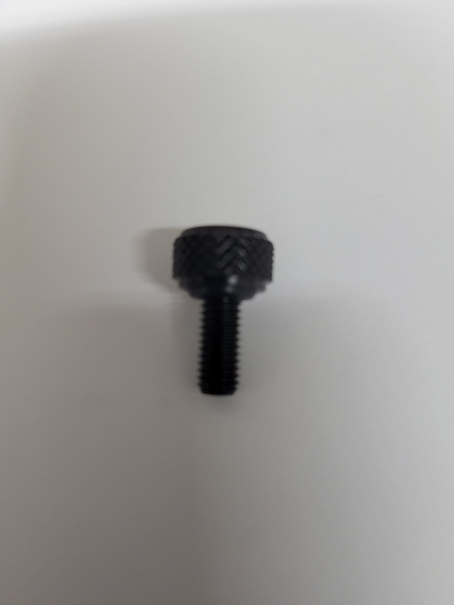 Close-up of black anodized aluminum bead lock screw with knurled head and O-ring