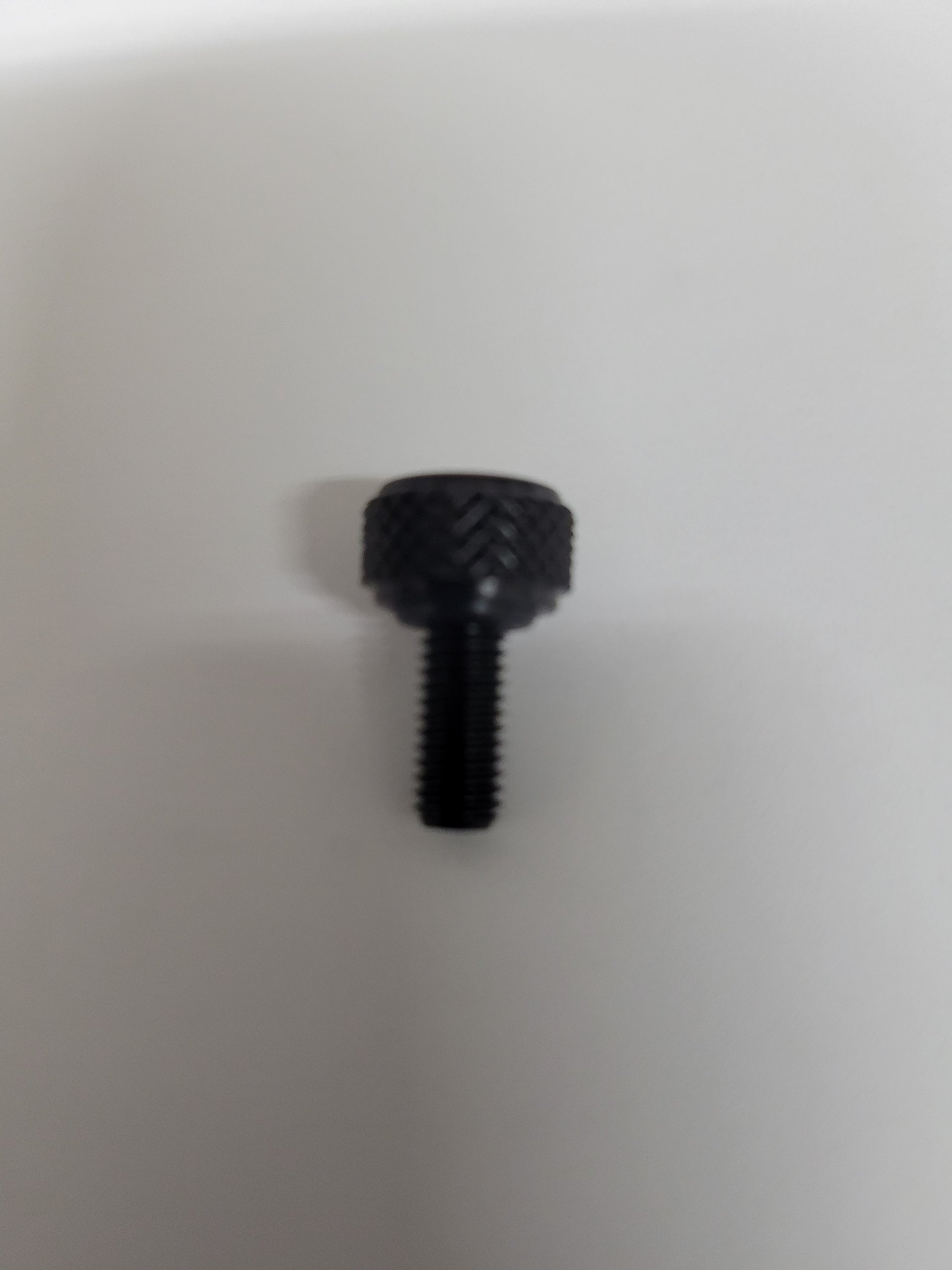 Close-up of black anodized aluminum bead lock screw with knurled head and O-ring