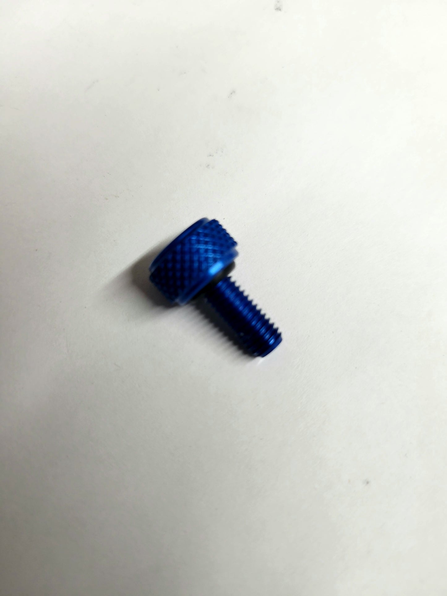 Close-up of blue anodized aluminum bead lock screw with knurled head and O-ring