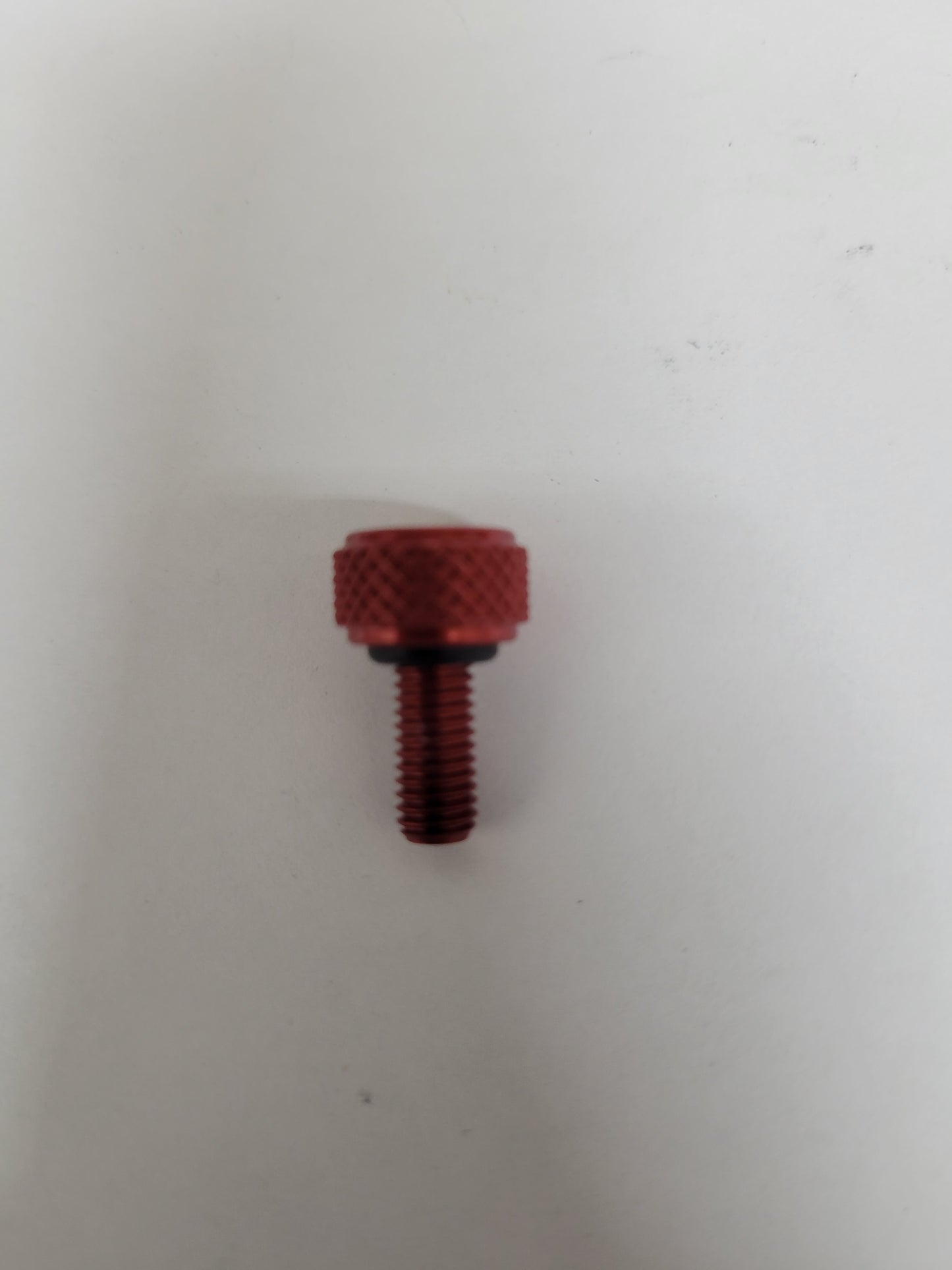 Red anodized aluminum bead lock screw with knurled head, O-ring, and 5mm thread for kart wheels