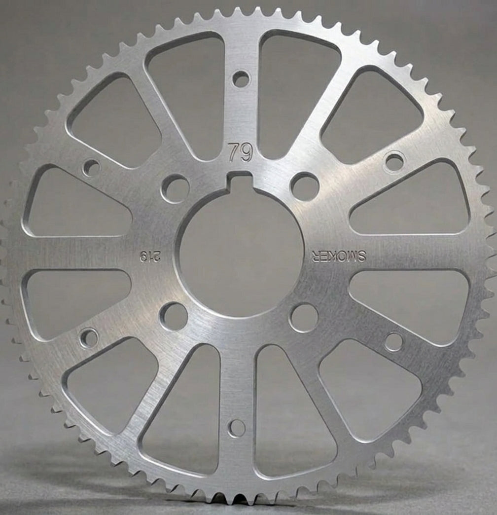 A silver metallic sprocket gear, photographed on a neutral gray background. The gear has engraved markings including '79', '612', and 'SMOKER' all marking are upside down except '79'.