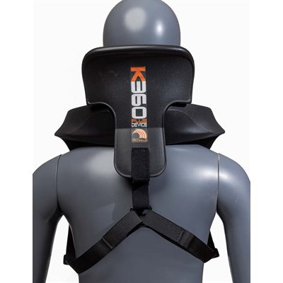Back view of K360 Plus Kid neck brace on child mannequin showing vertical logo, shoulder fit and crossed black harness system on a white background