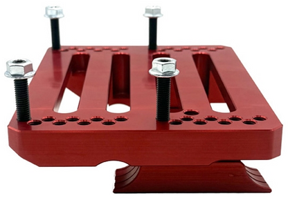Top view of assembled red Code Red engine mount with clamps and hardware installed showing slotted lightening pockets and perimeter mounting holes on white background