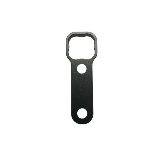 Black anodized billet aluminum wrench for Tuff-Kase II showing custom clover-shaped drive head, central locating hole, and lower grip hole on a white background