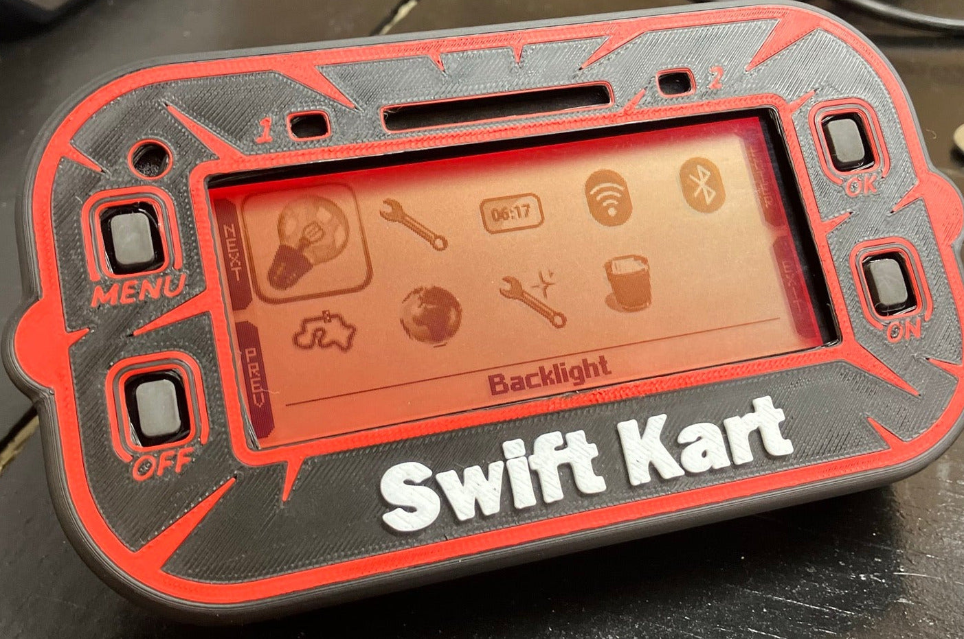 Black Mychron 6 Case, Red Design with  White Text. Mychron 6 unit installed inside of case, sitting at angle with orange illuminated background.