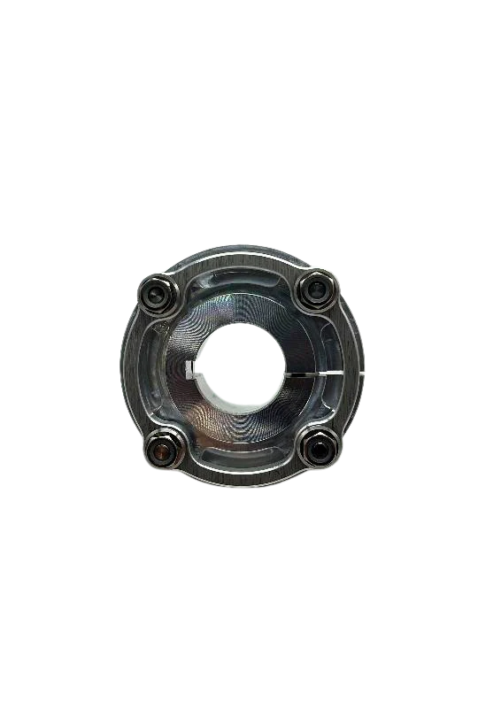 Top-down view of mini sprocket hub face highlighting machined 7075 grain pattern and four sprocket mounting holes on black background