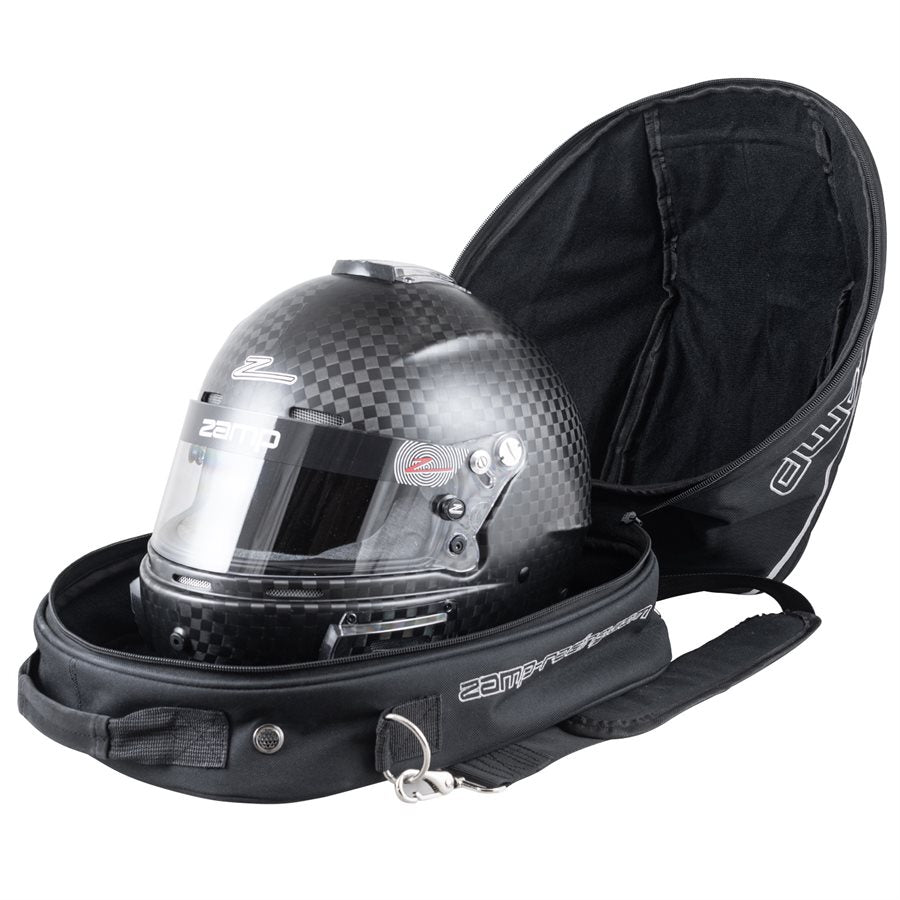 Open black Zamp helmet bag with fan containing a carbon fiber kart racing helmet to demonstrate scale fit and soft interior lining on a white background